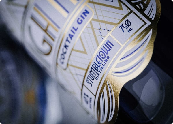 Close-up of a wine bottle with a gold foil-stamped custom label catching the light Close-up of a wine bottle with a gold foil-stamped custom label catching the light